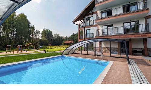 Oblasť Mazurských jazier blízko výletných cieľov: Apartament Karwica Zapach Lasu s bazénom, saunou a ihriskom 